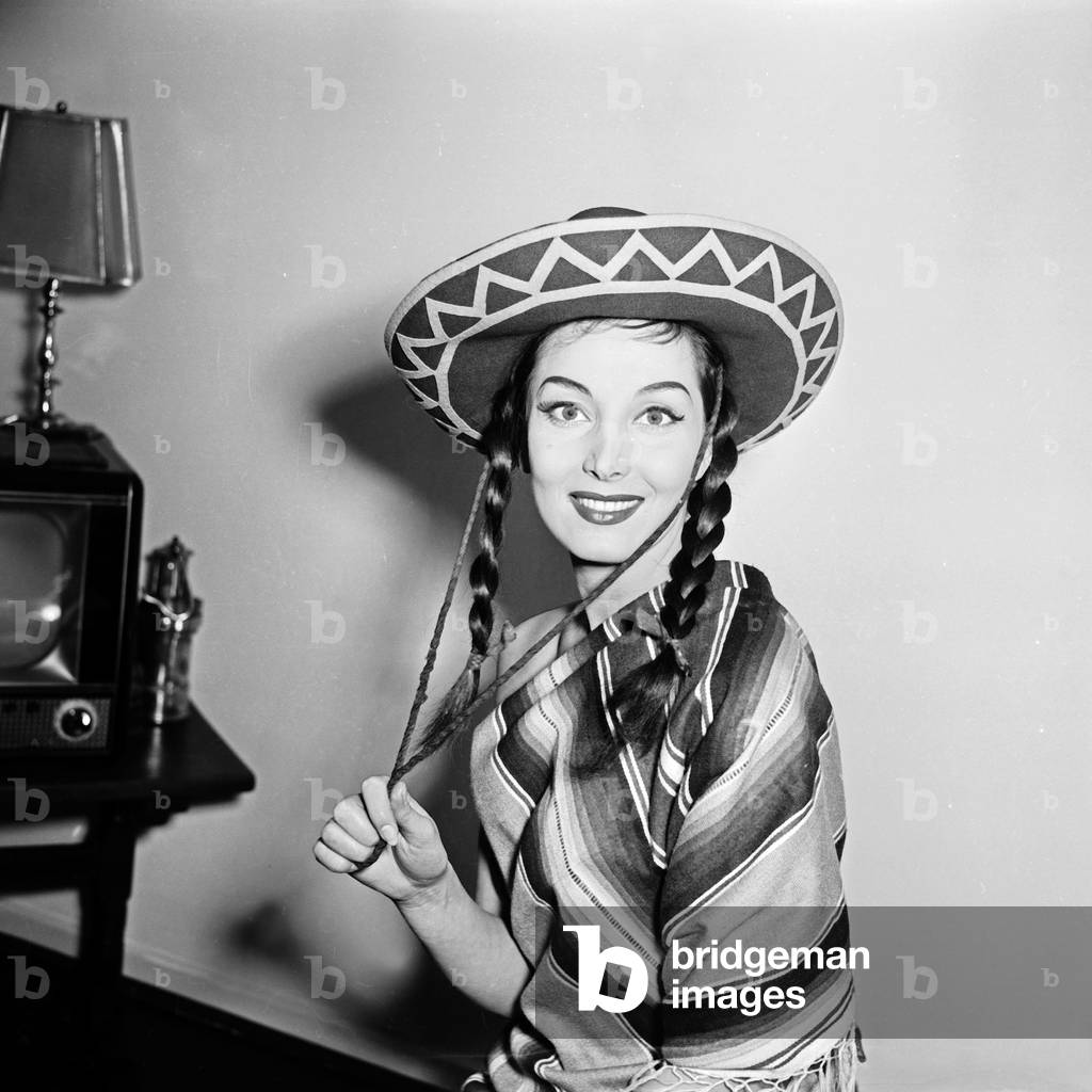 doing a promotional photo shoot wearing a poncho and a sombrero hat, Germany 1950s
