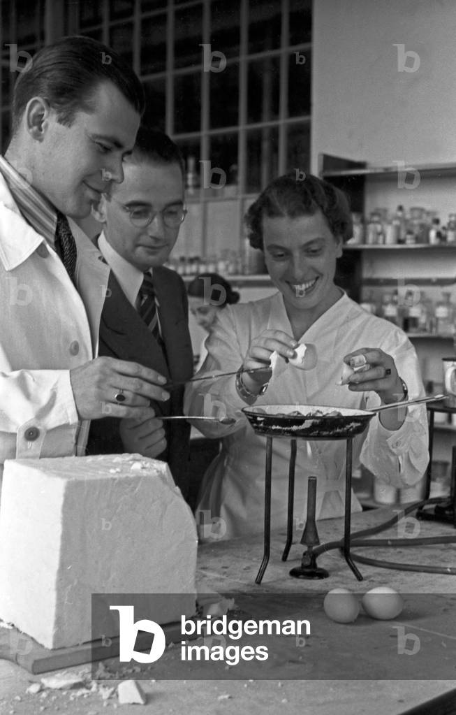 Scientific staff members of the Deutsche Fettsäurewerke and Maerkische Seifenindustrie company at Witten preparing fried eggs with margarine produced from coal, Germany 1930s (b/w photo)