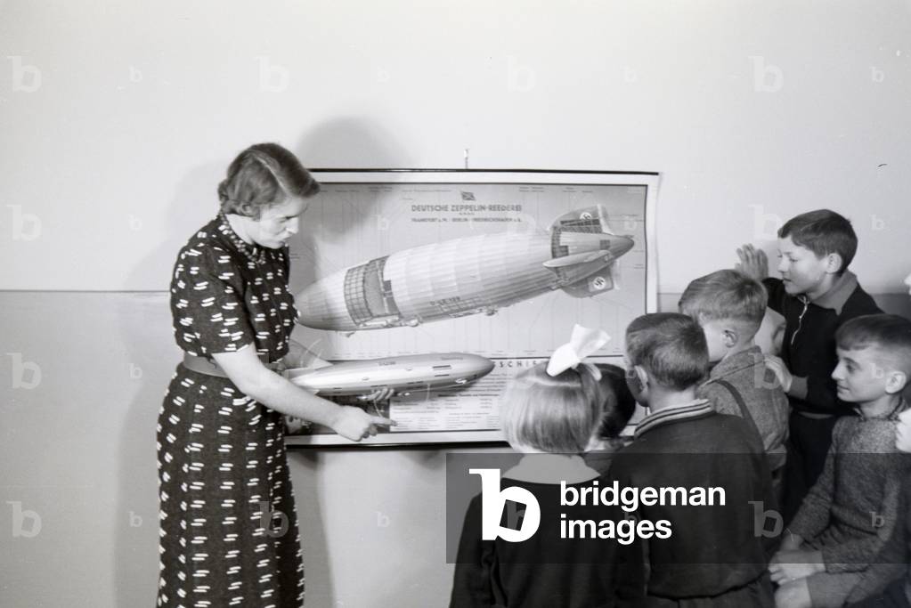 In the school of the zeppelin village near Frankfurt am Main, already the youngest pupils were instructed in the structure of a zeppelin by their teachers, here with the help of an aircraft model, Germany 1930s (b/w photo)