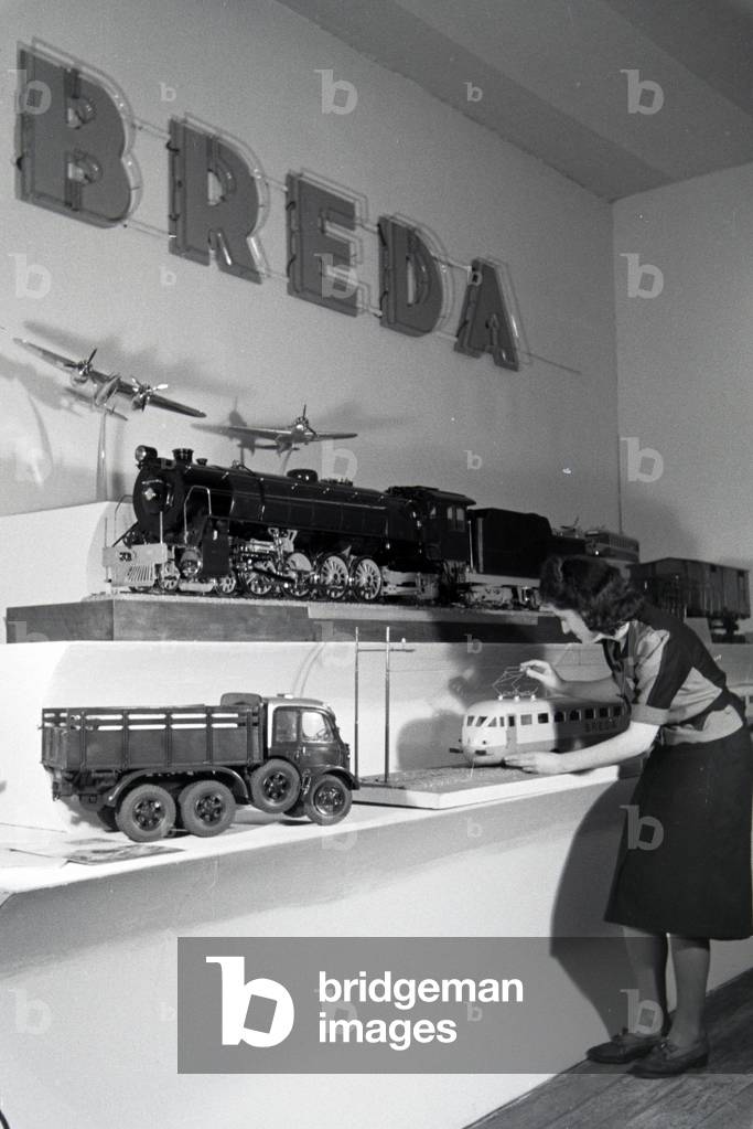 A visitors in front of a stand with models of the italian mechanical engineering corporation Breda on the Leipziger Frühjahrsmesse, Germany 1941 (b/w photo)