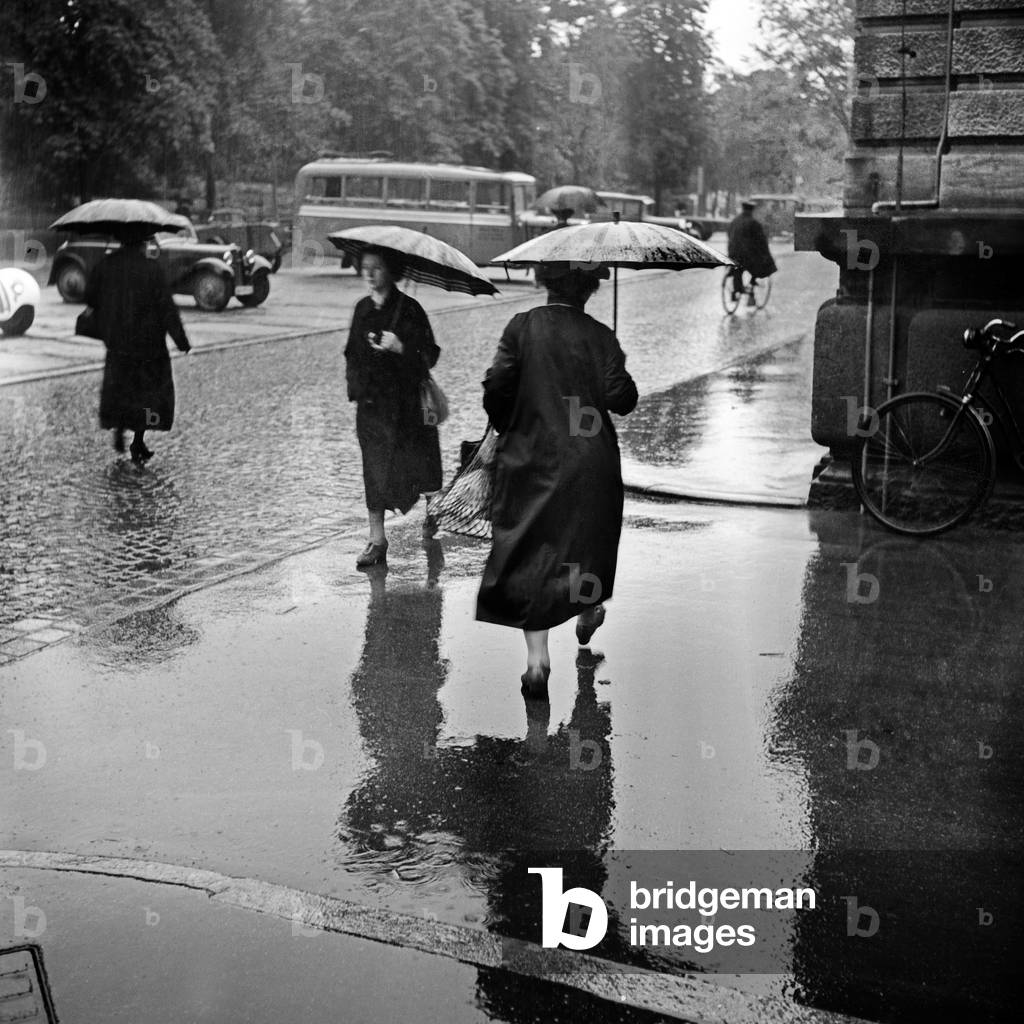 Women in the rain under an umbrella, Germany 1930s (b/w photo)