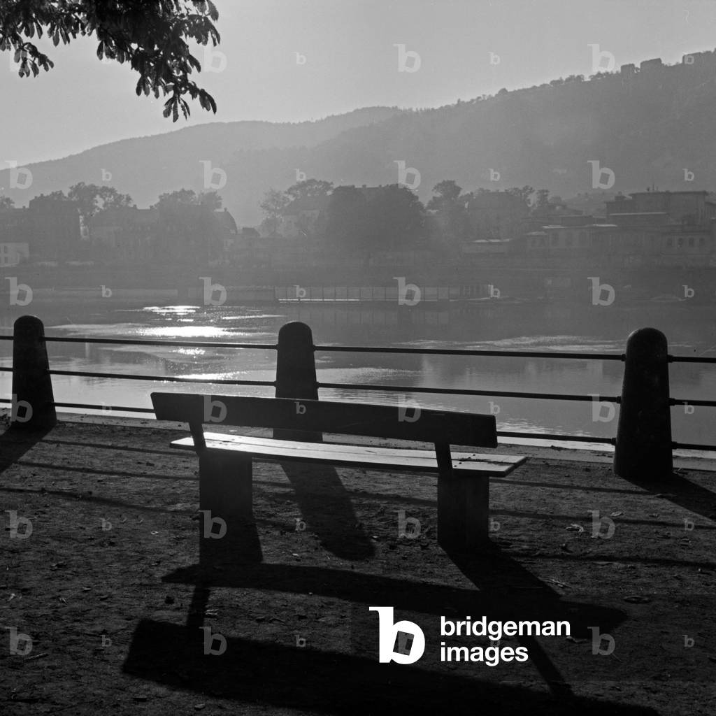 Bench in backlight on the shore of river Moselle at Trier, Germany 1930s (b/w photo)