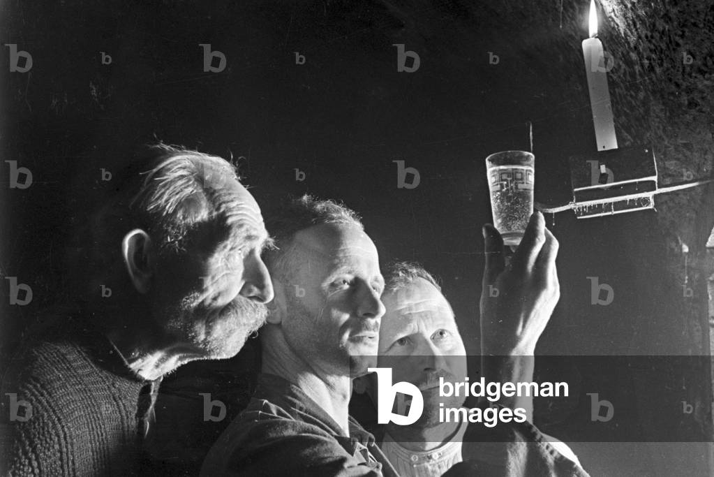 Three winegrowers checking the new vintage at the wine cellar, Germany 1930s (b/w photo)