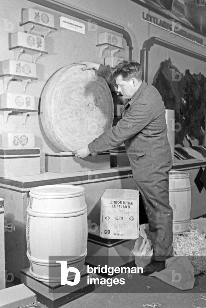 Workers carrying butter and cheese from Latvia to the booth at the Leipzig trade show, Germany 1940s (b/w photo)