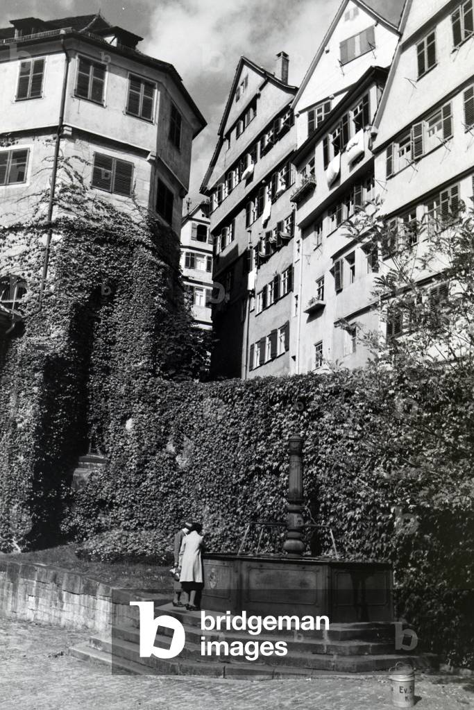 The water well with inscription on the patio of the Protestant church foundation, Tübingen, Germany 1930s (b/w photo)