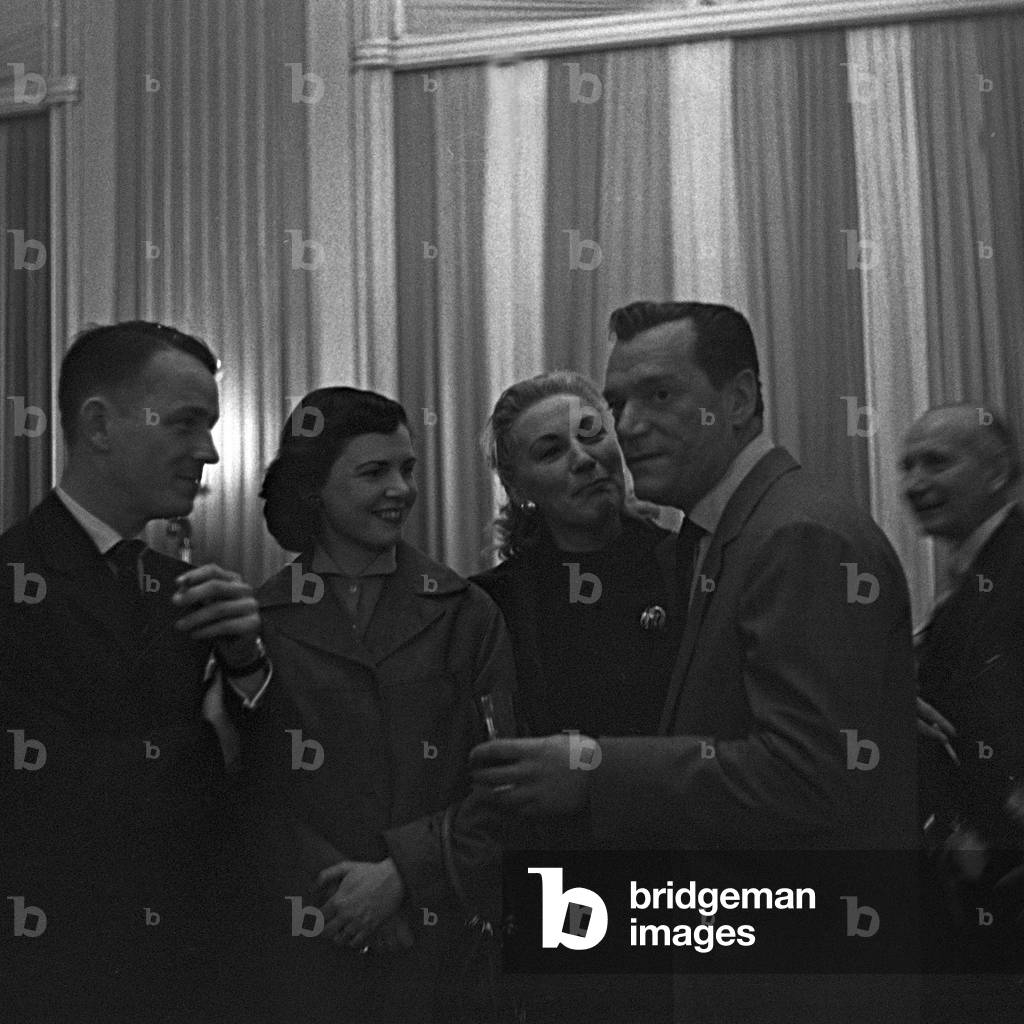 American actor and chansonnier Eddie Constantine with admirers at a restaurant at Hamburg, Germany 1950s