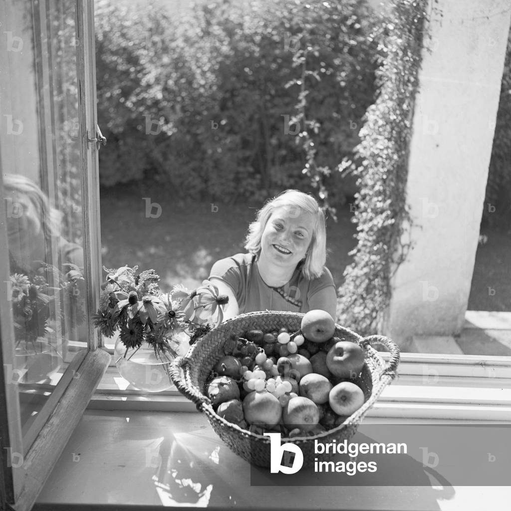 A young woman, seen through a window, Germany 1930s (b/w photo)