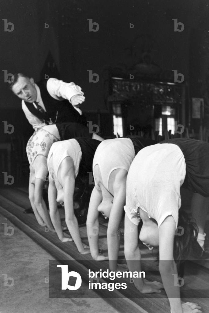 Man with girls at a circus artist's school, Germany 1930s (b/w photo)