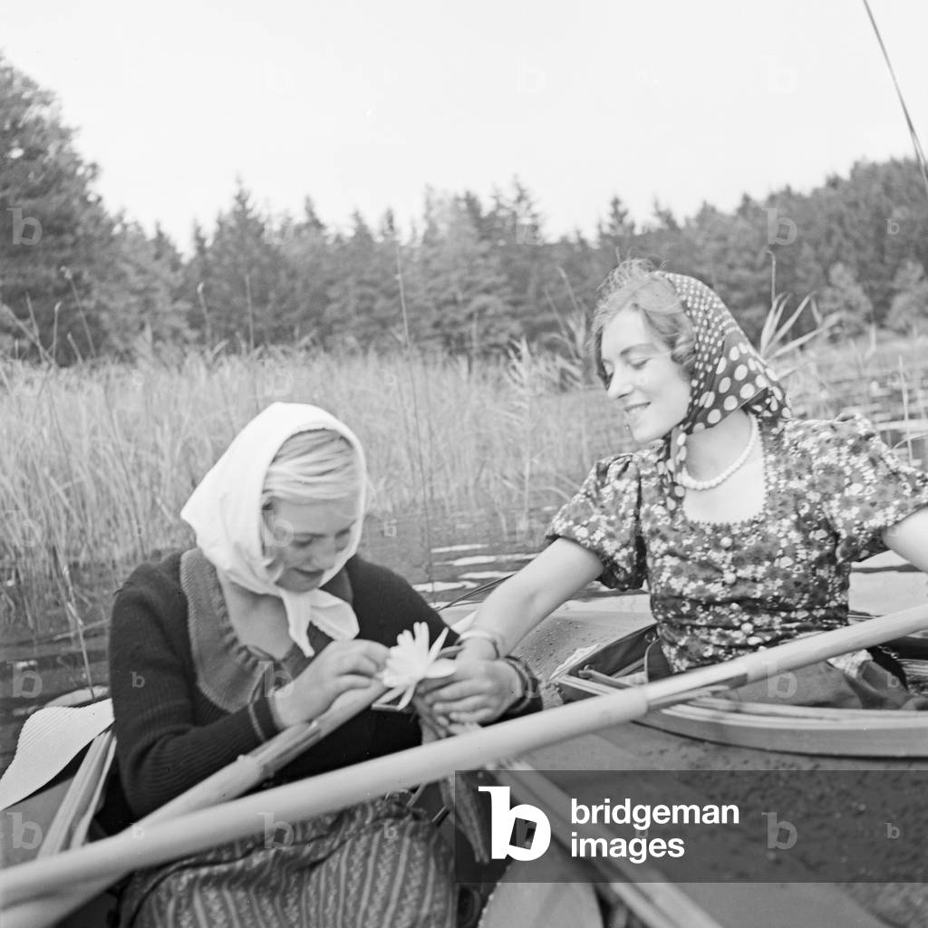 Two young women at a boardwalk on the shore of a lake in the Wachau area, Germany 1930s (b/w photo)