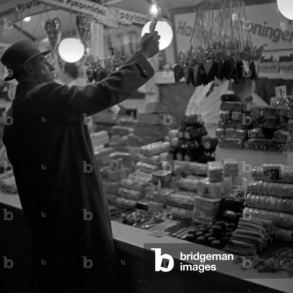 A man at the candy booth of the Berlin Stralau annual fair, Germany 1930s (b/w photo)