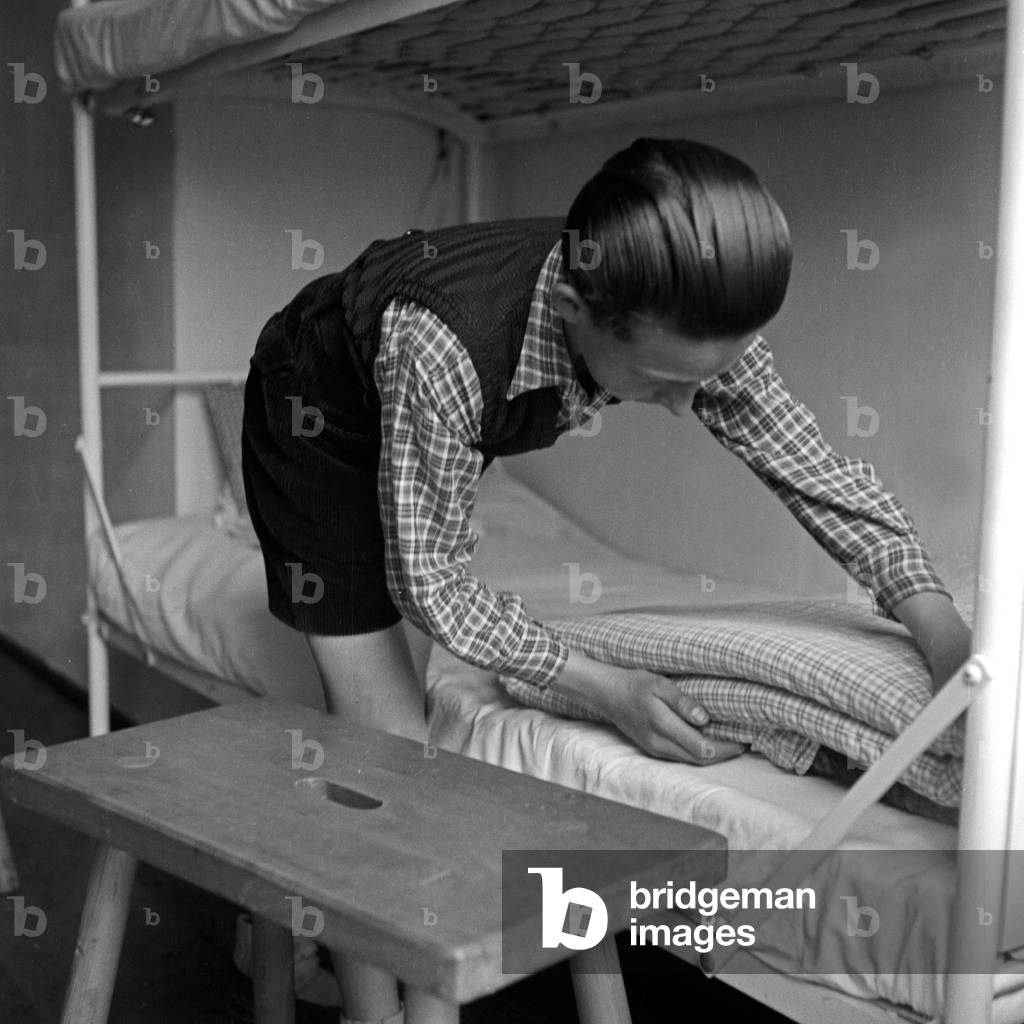 Boy at the Adolf-Hitler-youth hostel at Berchtesgaden preparing their beds, Germany 1930s