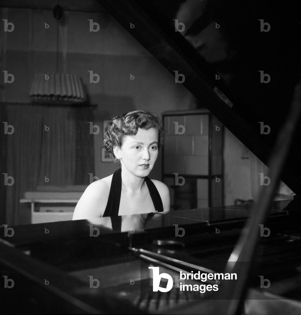 A young woman playing a grand piano