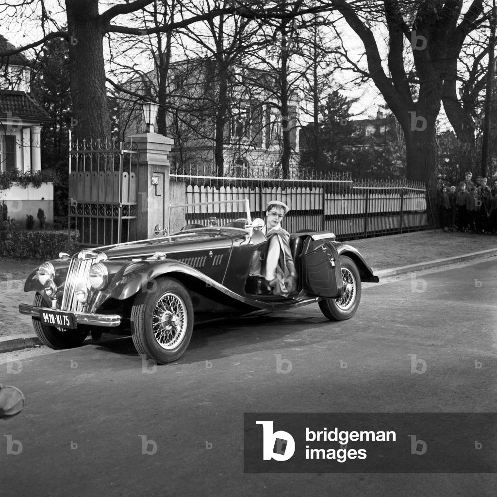 A young woman gets off of a MG TF convertible at Hamburg, Germany 1950s