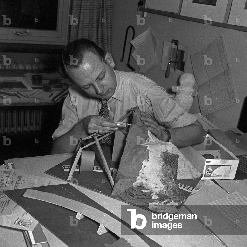 A man modeling a tunnel for his model train, Germany 1950s
