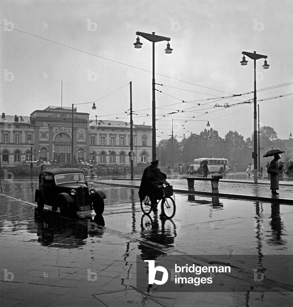 People in a hurry on the square in front of Braunschweig main station, Germany 1930s (b/w photo)