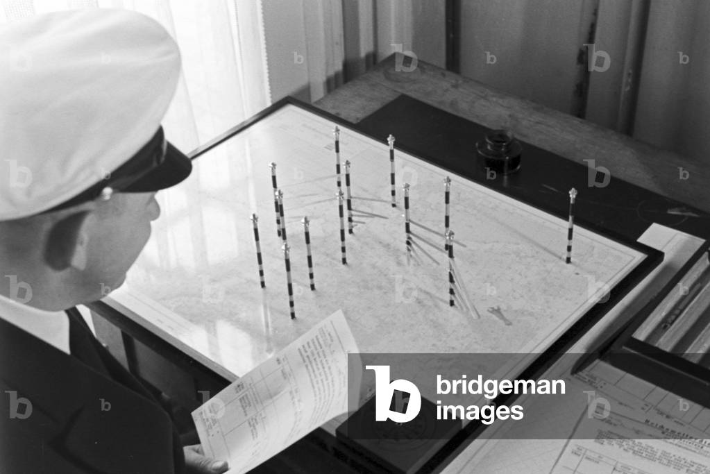 Staff member of a meteorological office working with maps, Germany 1930s (b/w photo)