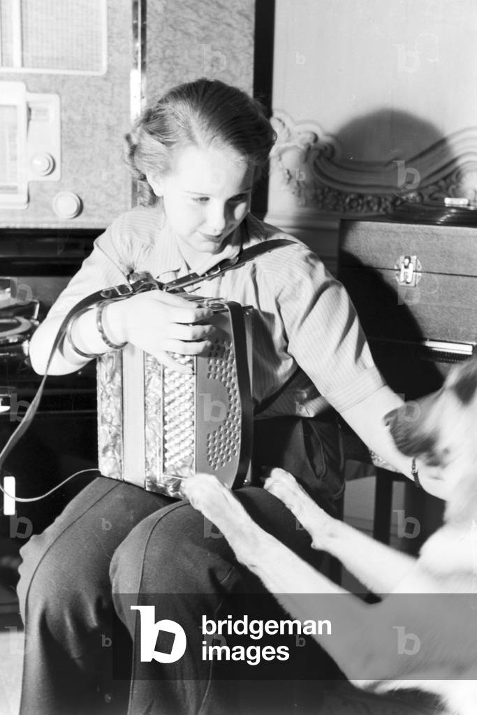 Family music: the princess of carnival in Mainz 1938, on the occasion of the 100th anniversary of the leading local carnival association, at home with her accordion in Nieder-Olm (b/w photo)