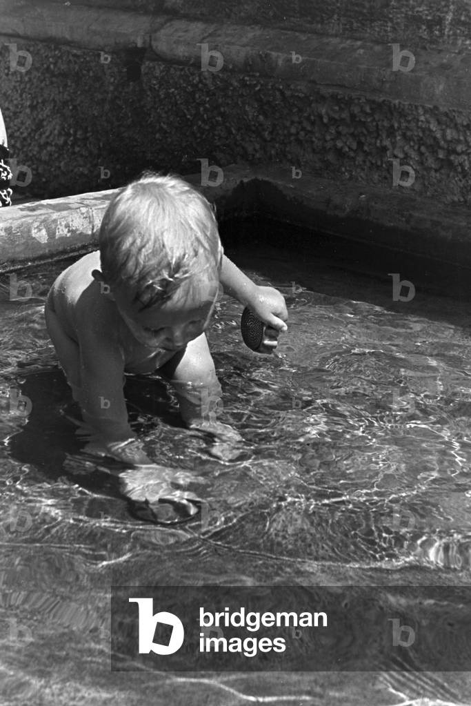Playing toddlers in the open-air swimming pool on a hot summer day, Germany 1930s (b/w photo)