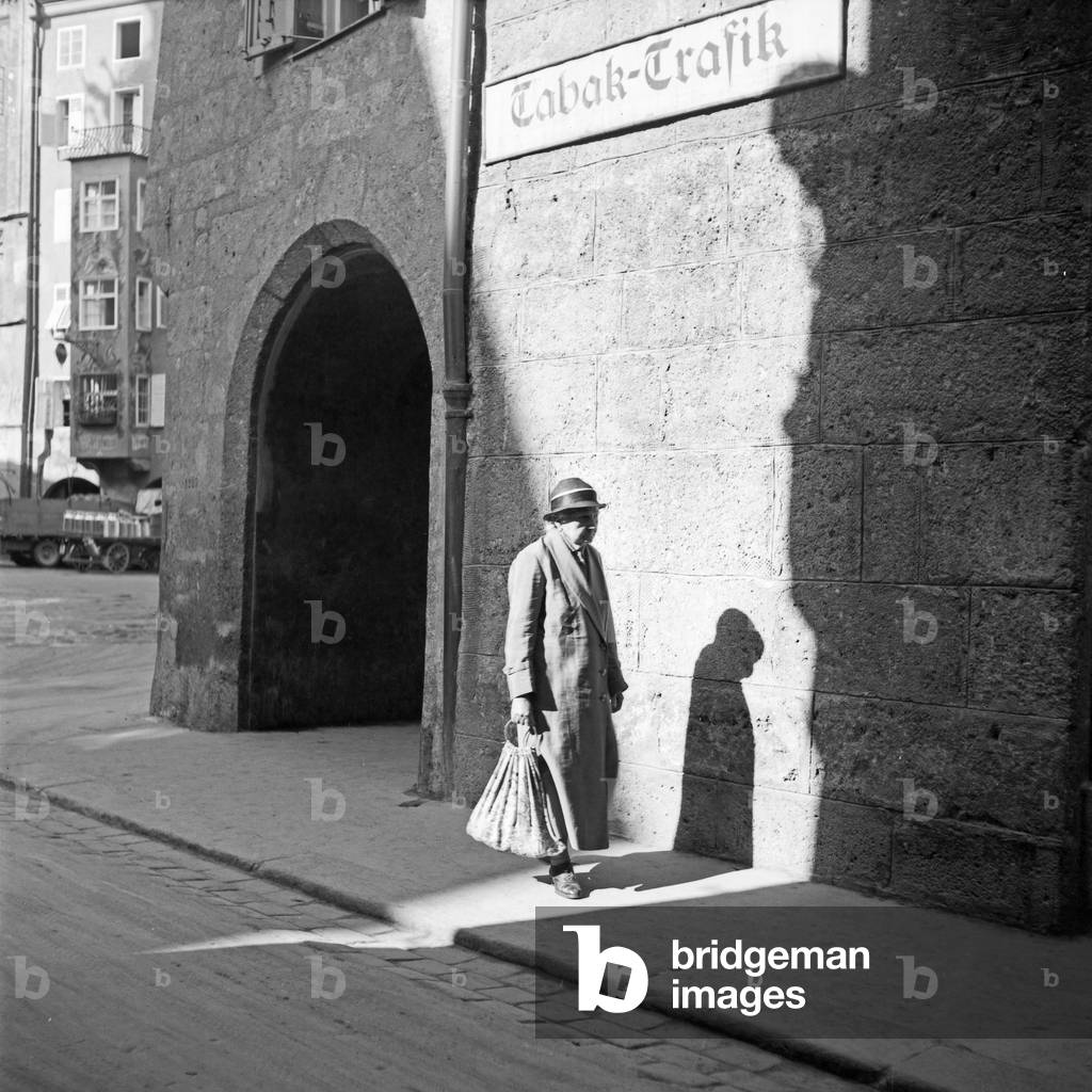 An elder lady strolling throuig the streets of Innsbruck in Austria, Germany 1930s (b/w photo)