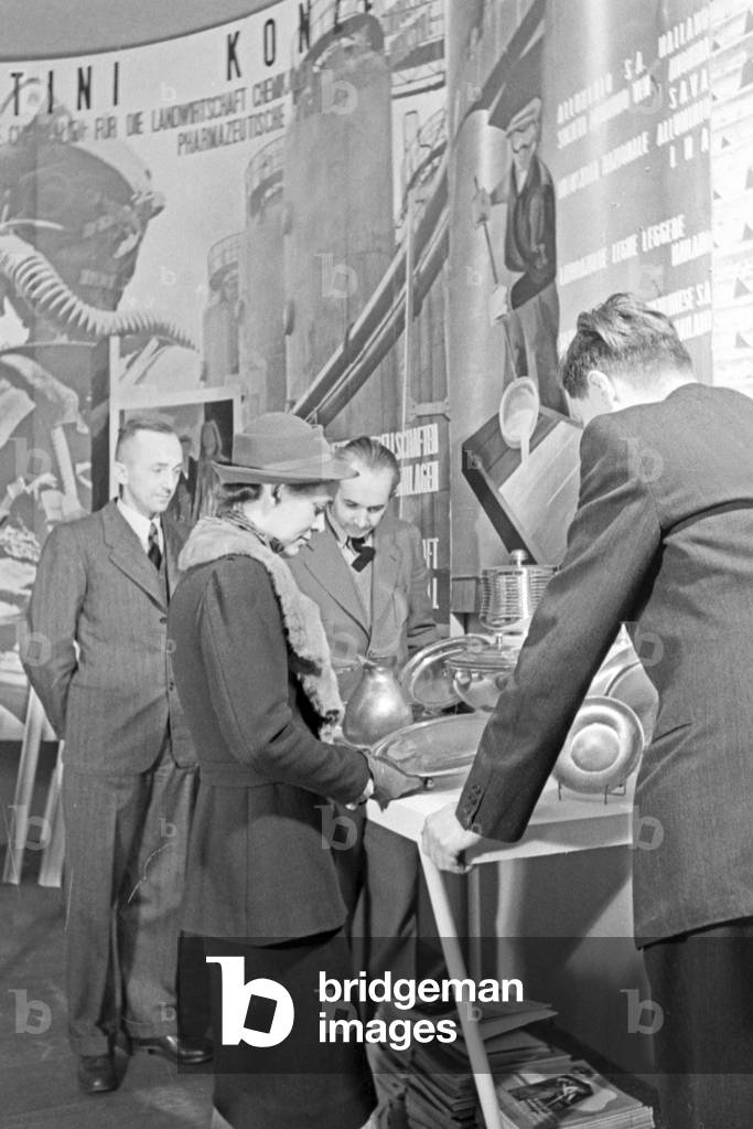 Surely the ladies see the exhibits at the booth of household supplies at the Leipzig trade show, Germany 1940s (b/w photo)