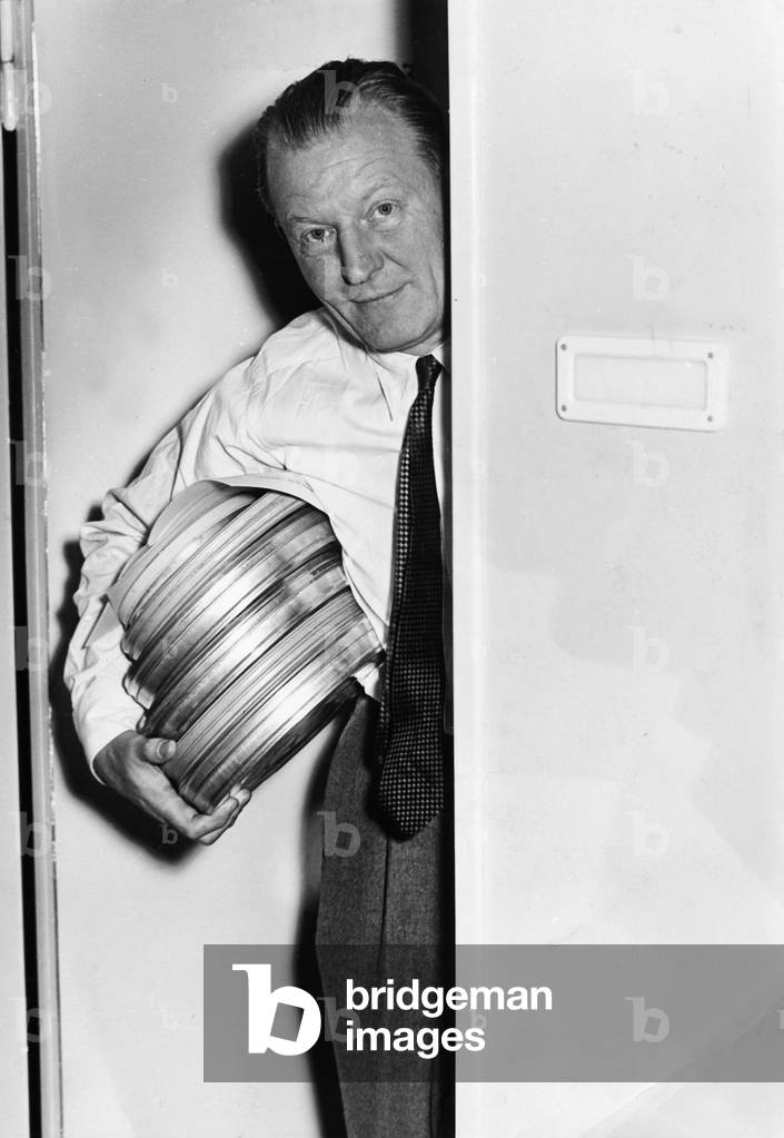 German radio- and TV-journalist Peter von Zahn leaving the archives with some film reels , ca beginning 1960s