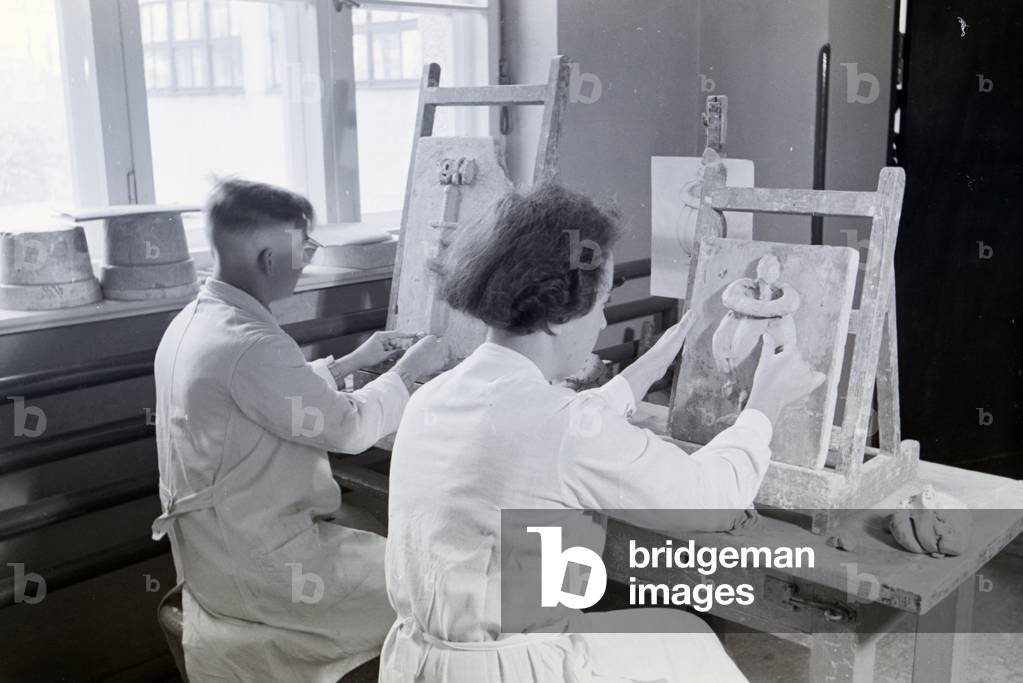 Students of the College for Ceramics working on reliefs in the working ateliers, Höhr-Grenzhausen, Germany 1930s (b/w photo)