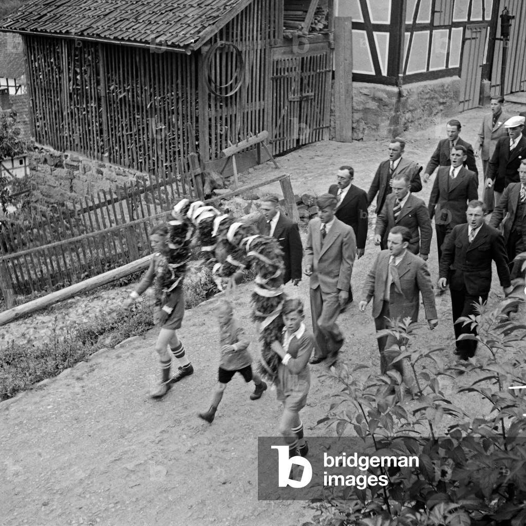 Procession with young men at the Schwalm area, Germany 1930s (b/w photo)