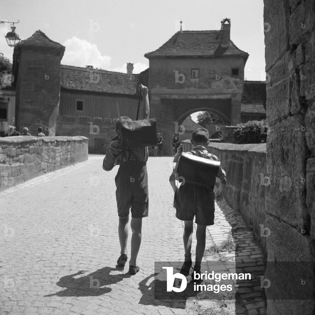 Two school kids on their way home at Rothenburg ob der Tauber, Germany 1930s (b/w photo)
