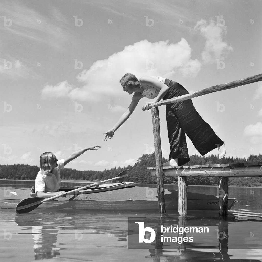 Two young women at a boardwalk on the shore of a lake in the Wachau area, Germany 1930s (b/w photo)