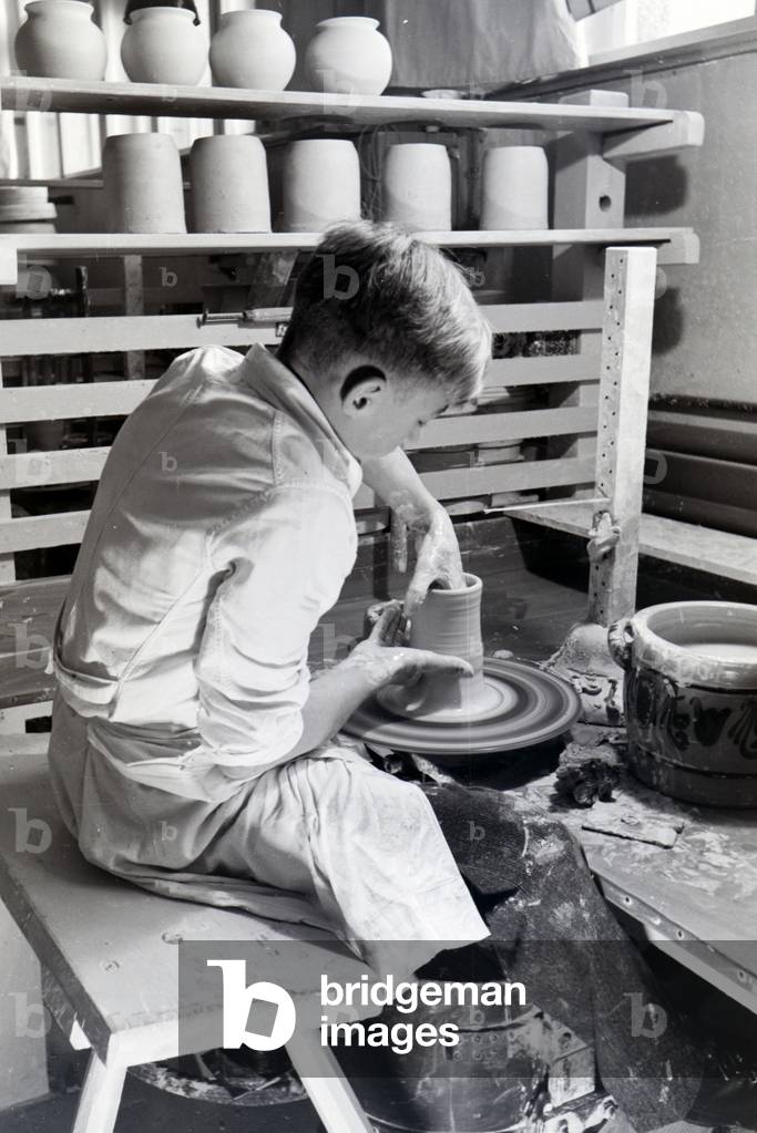 A student of the College for Ceramics working on the pottery wheel in the working ateliers, Höhr-Grenzhausen, Germany 1930s (b/w photo)