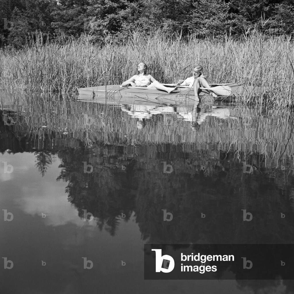 Two young women at a boardwalk on the shore of a lake in the Wachau area, Germany 1930s (b/w photo)