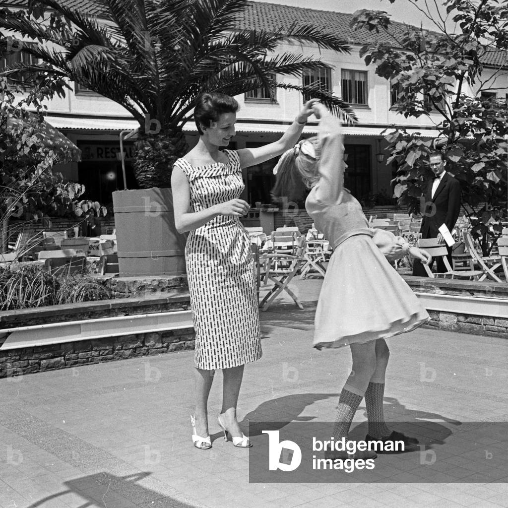 German television announcer Irene Koss with a child from Berlin at Planten un Blomen public gardens in Hamburg, Germany 1950s