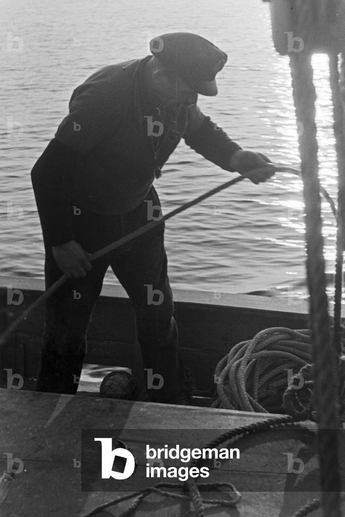 A deep sea fisherman working on deck, Germany 1930s (b/w photo)
