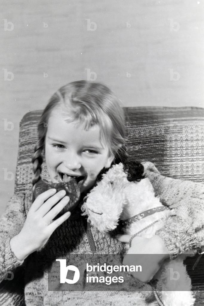A girl eating Liegnitzer Bomben, Germany 1930s (b/w photo)