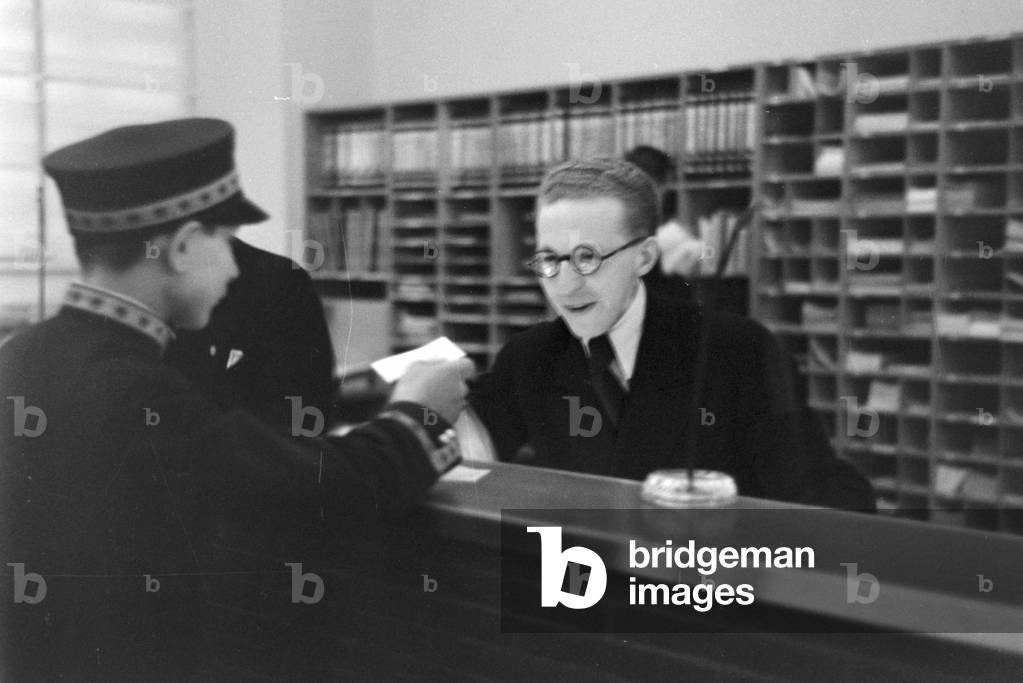 Travellers and staff members at a huge office of a travel agency in Berlin, Germany 1930s (b/w photo)