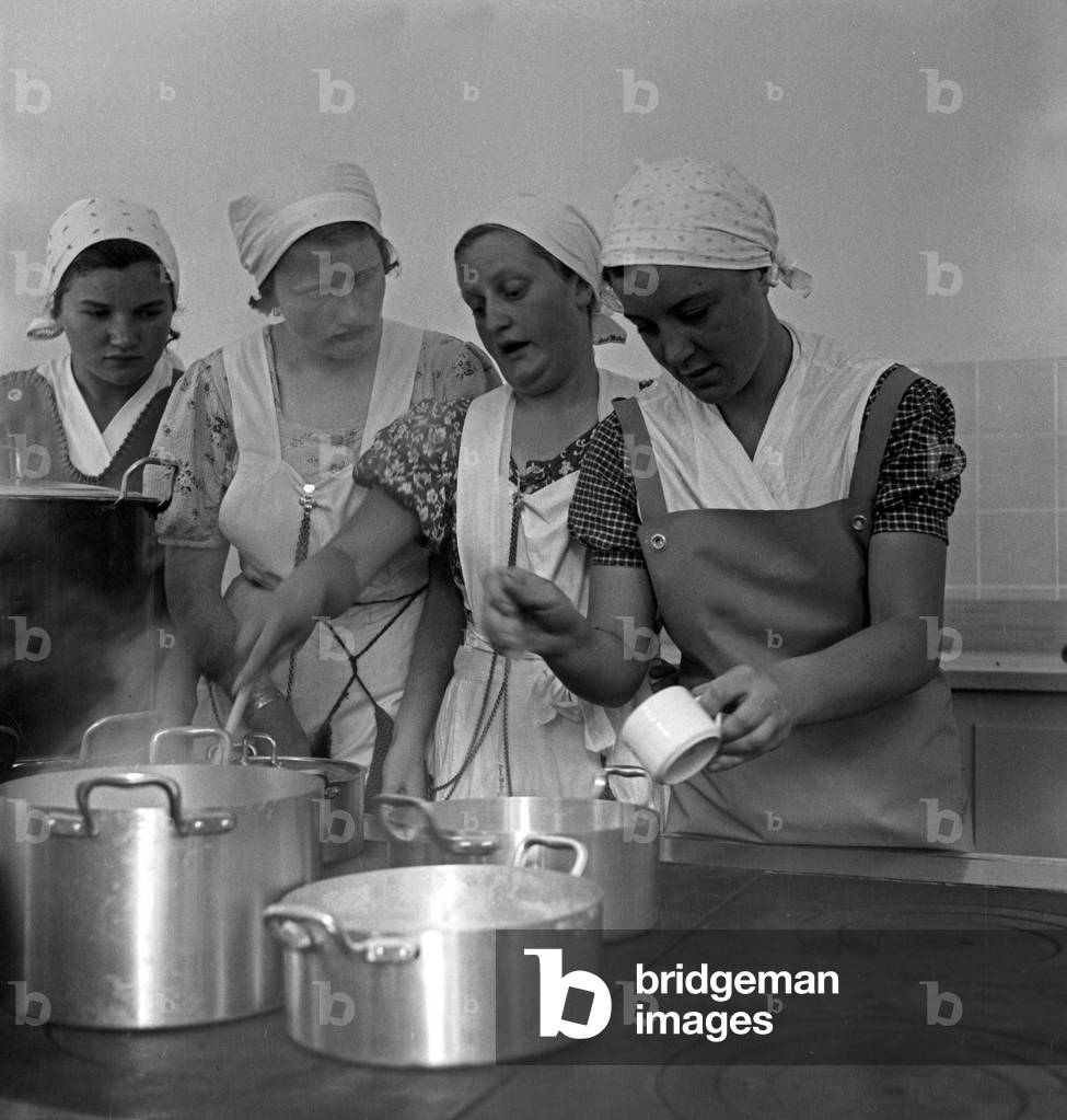 BdM girls learning how to cook at the kitchen of the school for home economics at Greifenberg, Germany 1930s (b/w photo)