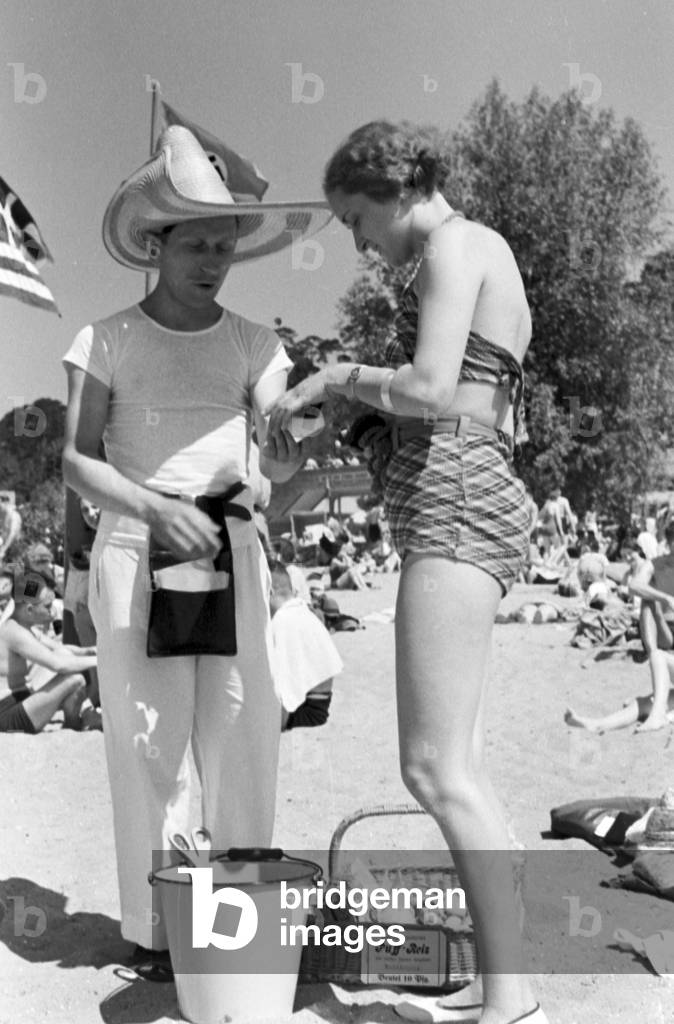 Swimming beauty buying an ice cream at lake Wannsee lido in Berlin, Germany 1930s (b/w photo)