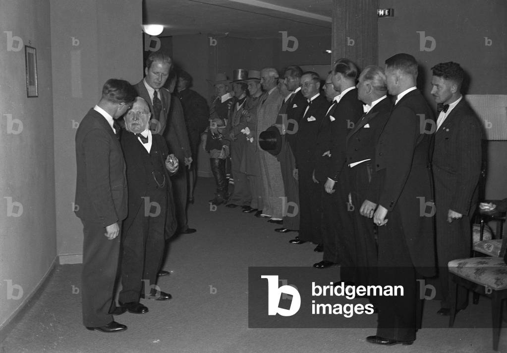 A music crew around a musician at the broadcasting building in Berlin, Germany 1930s (b/w photo)