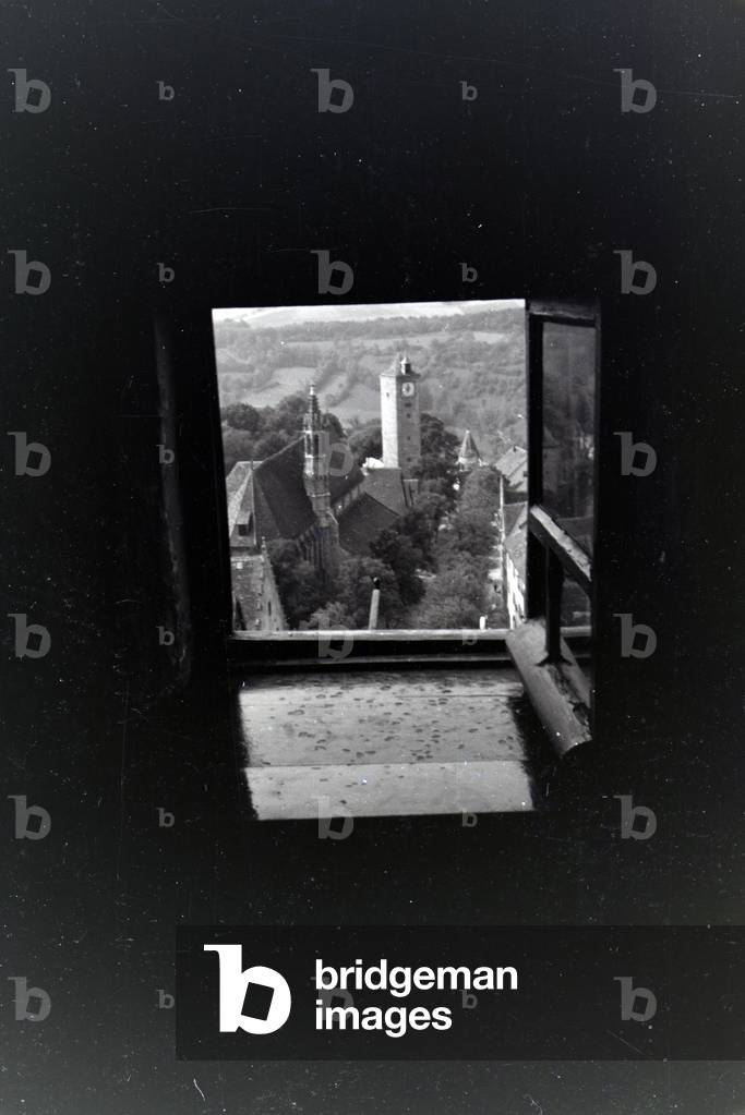 View out of a little tower window onto the many tiled roofs of the city Rothenburg ob der Tauber, Germany 1930s (b/w photo)
