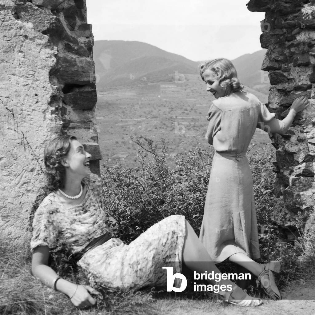 Two young women at the remains of a castle in the Wachau area in Austria, Germany 1930s (b/w photo)