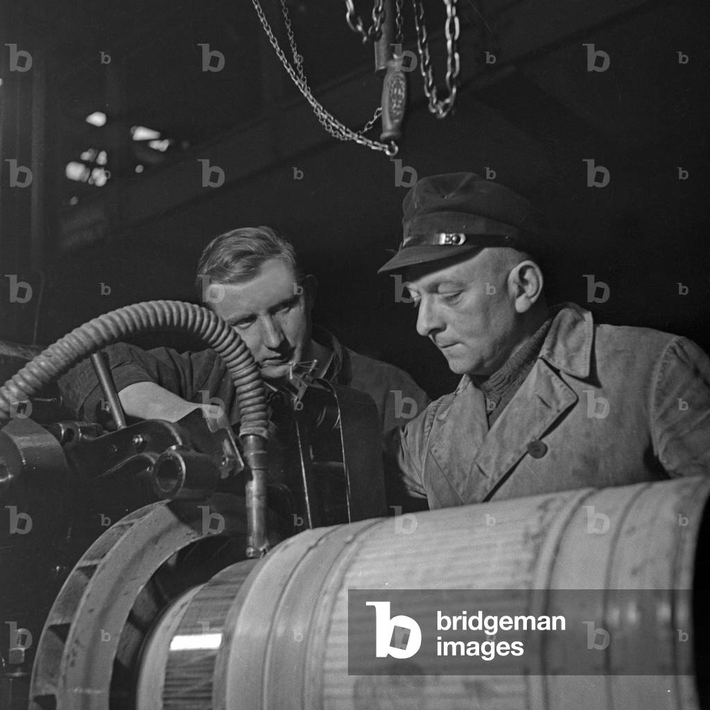 Two workers at their working place at a roll thread factory, Germany 1930s (b/w photo)