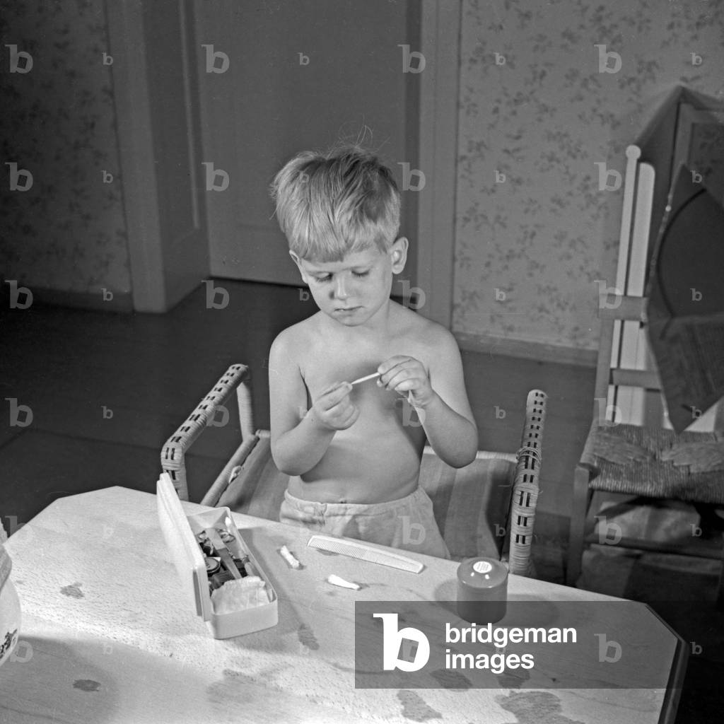 A little boy cleaning his fingernails, Germany 1930s (b/w photo)
