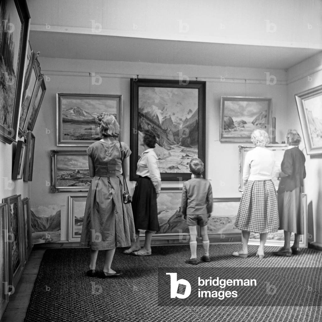 Visitors watching paintings at an exhibition, Germany 1950s