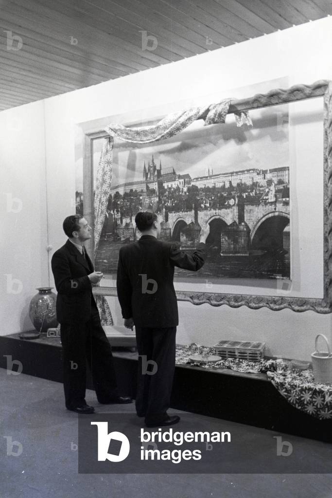 Visitors of the Leipziger Frühjahrsmesse in front of a panoramic photography of the city Prague, Germany 1941 (b/w photo)