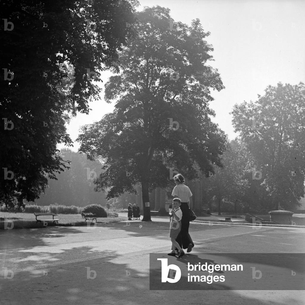A little boy on the hand of his mother strolling through Bad Homburg, Germany 1930s (b/w photo)