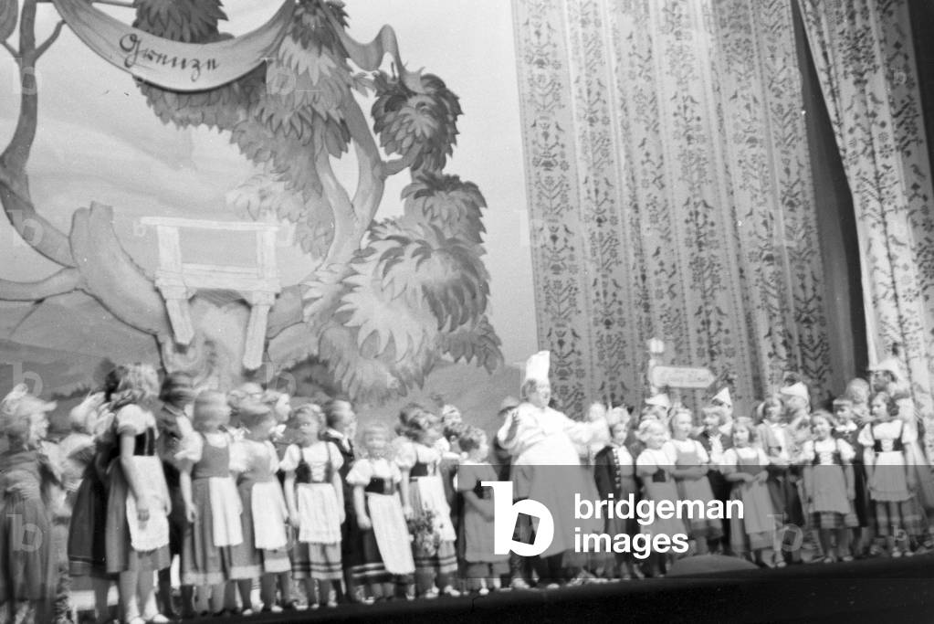 The lavishly designed stage set and the numerous actors during a children´s theatre play, Germany 1930s (b/w photo)
