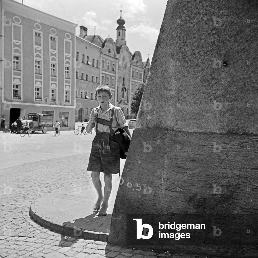 A schoolboy on his way home from school throug hthe streets of Burghausen, Germany 1930s (b/w photo)