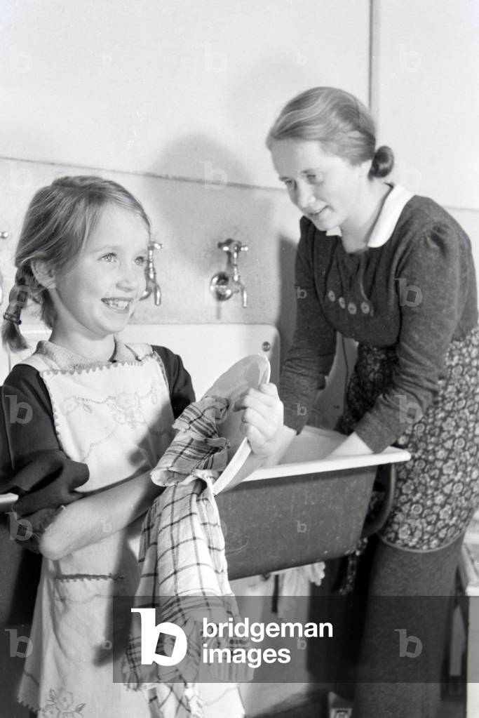 Members of a extended family doing the housework, Germany 1930s (b/w photo)