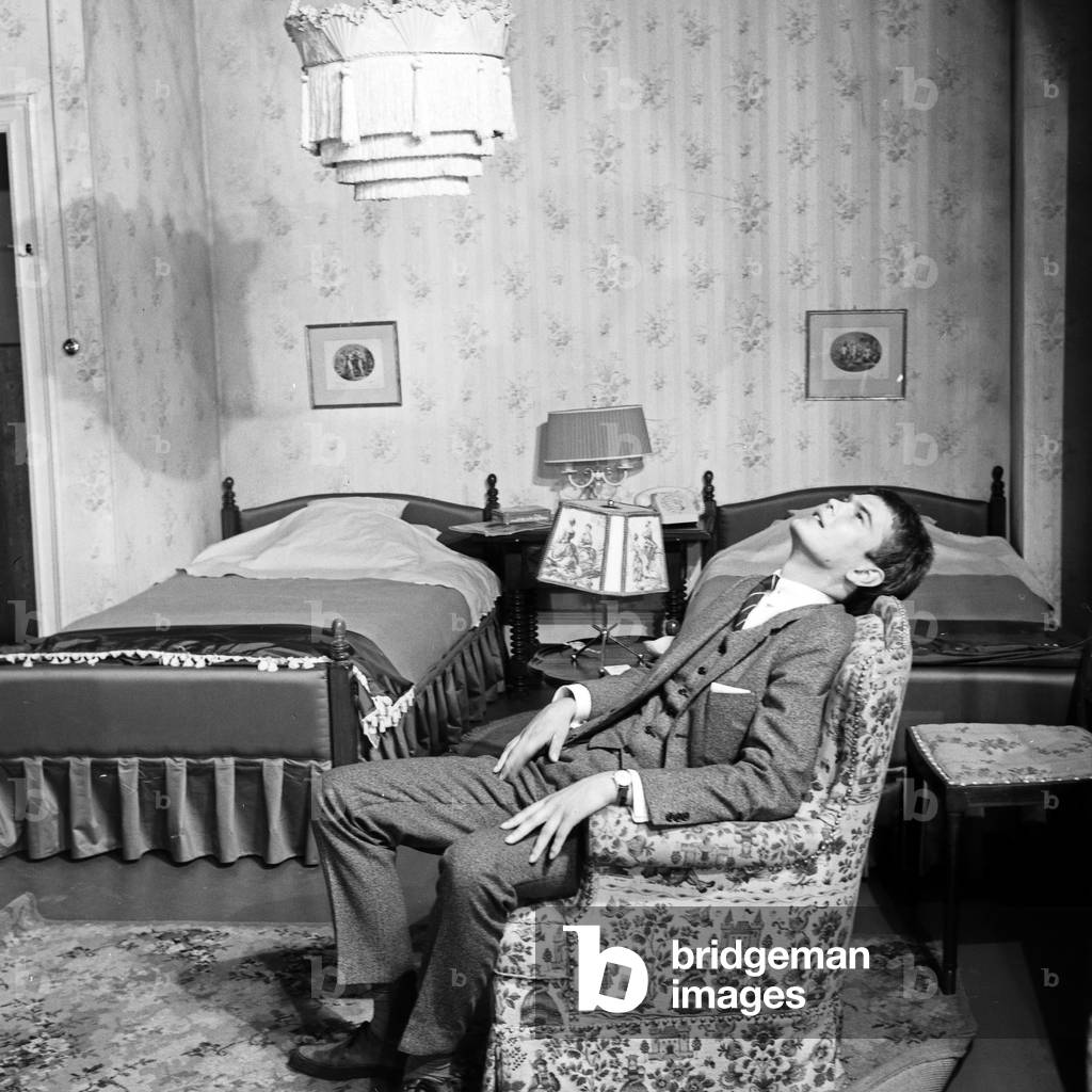 A tired young man sitting on a chair, Germany 1960s