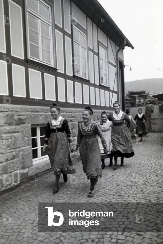 Female cigar rollers wearing a Marburg garb, costume in the courtyard of a cigar fabric near Marburg, Germany 1930s (b/w photo)
